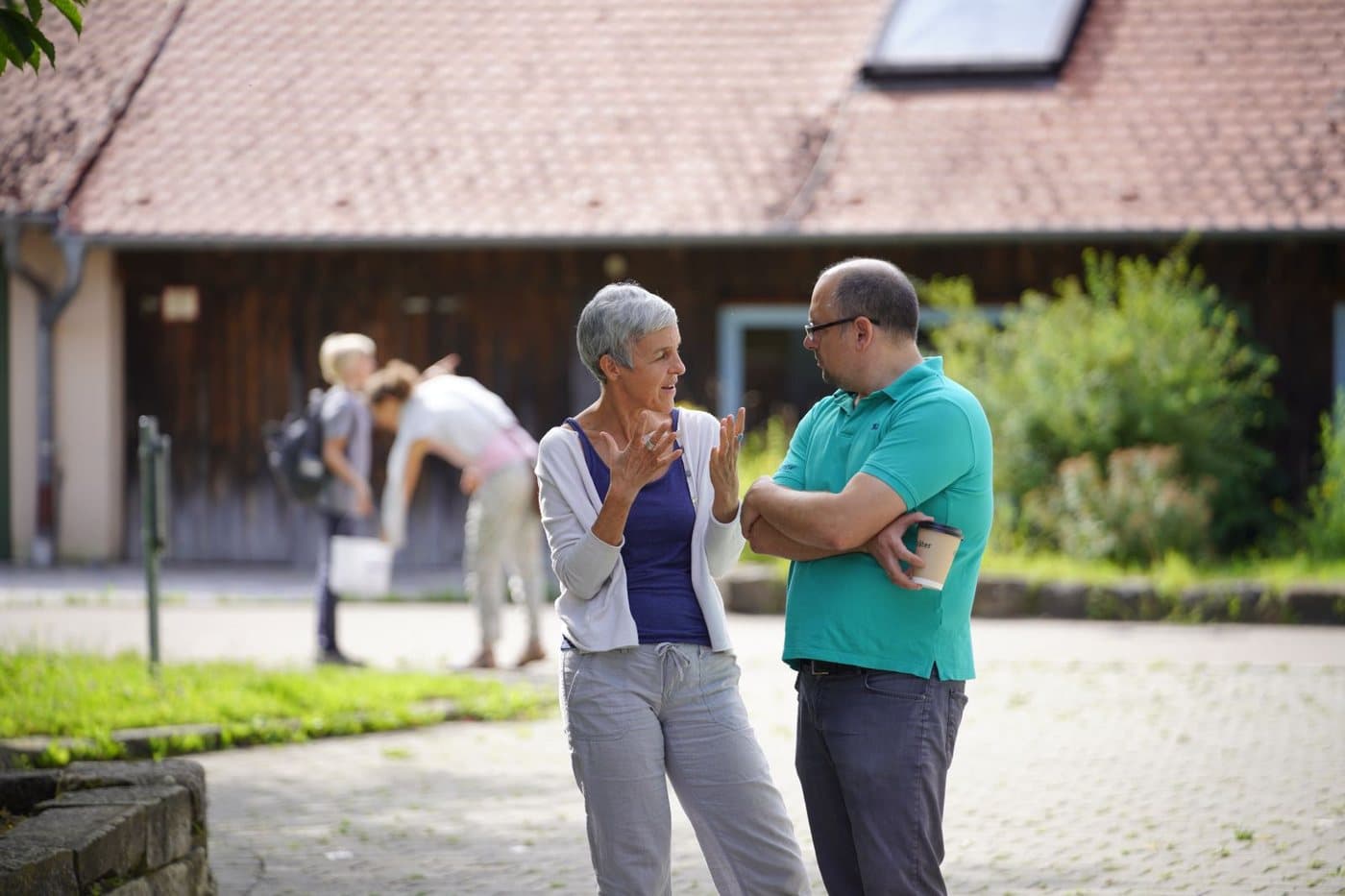 Zwei Menschen aus dem Kollegium im Gespräch auf dem Schulhof